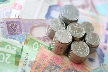 Few stacks of ukrainian money coins lies on old hryvnia banknotes