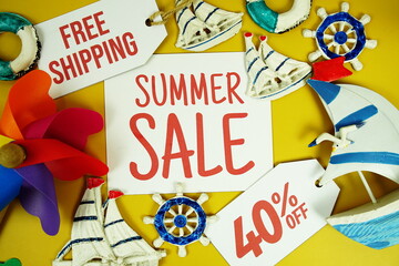 SUMMER SALE 40% OFF text on paper card with marine items decorative top view on yellow background