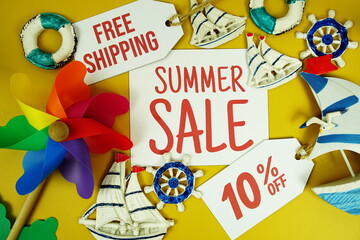 SUMMER SALE 10% OFF text on paper card with marine items decorative top view on yellow background