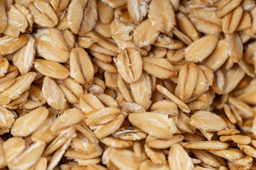 Close-up of raw rolled oats, showcasing their natural texture and nutritional value, ideal for healthy eating and organic food concepts.