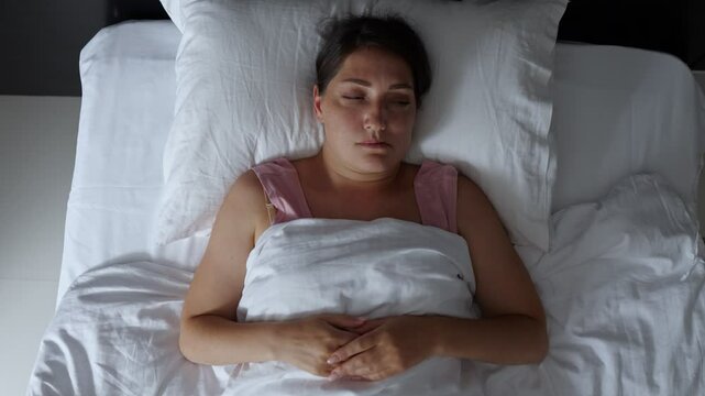 Woman tossing and turning in bed having trouble sleeping