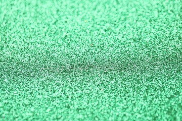 Obraz premium Beautiful green glitter sparks texture as background with shallow depth of field
