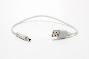 Fototapeta premium Short white cable with USB-A on one side and other device charging connector at the end