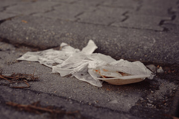 Trash discarded on city street showcases urban litter issues and environmental concerns in a...