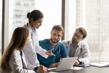 Group of multinational doctors gathers together to discuss patient case, listen speech of...