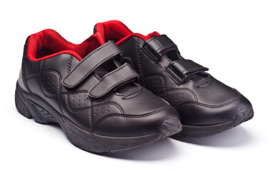 A pair of black leather shoes with velcro straps and a bold red interior lining, showcased on a clean white background.  