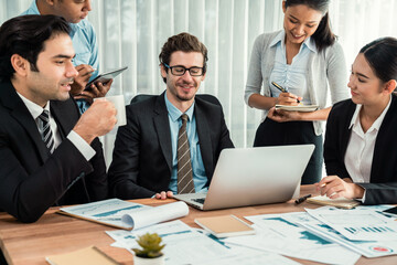 Diverse group of business analyst team analyzing financial data report paper on office table. Chart and graph dashboard by business intelligence analysis for strategic marketing planning Habiliment