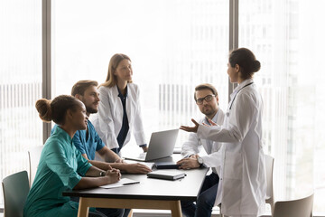 Indian doctor wear white coat perform during medical concilium event with professional colleagues, hospital staff members, provide explanation, offers solutions, during discussion patient disease case