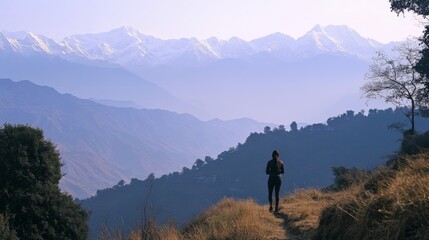 Obraz premium Female hiker enjoying scenic mountain view with snow-capped peaks under clear sky
