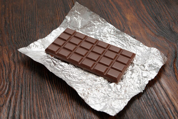 Broken dark chocolate on a wooden table