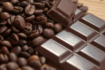 Broken dark chocolate and coffee beans on a wooden table
