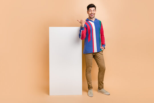 Full body photo of businessman marketing specialist promoting his google adsense stats at phone display isolated on beige color background