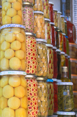 A row of jars with pickles and olives