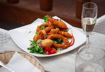 seafood delicacies on plates and a glass of champagne