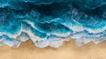 Aerial view of turquoise ocean waves crashing on a sandy beach, creating a beautiful contrast in colors and textures.