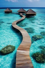 Scenic overwater bungalows connected by a winding boardwalk above clear turquoise ocean waters and coral reefs beneath a blue sky.