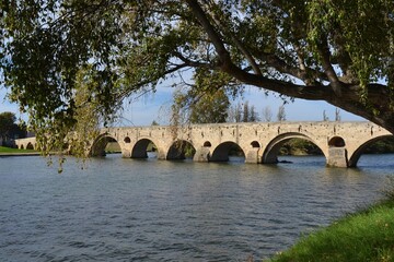 Historic stone bridge spanning a tranquil river landscape