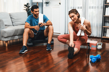 Obraz premium Athletic body and sporty young couple or workout buddy in sportswear warmup or resting after finishing in home workout exercise at gaiety home exercise and healthy lifestyle concept.