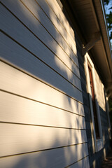 Sunlight Shadow on Wooden House Wall: Architectural Photography of Modern Home Exterior