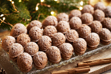 Nut shaped homemade Christmas cookies filled with cream, with cinnamon and fir tree branches