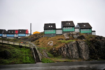 Greenland. Colorful houses dot the rugged coastline of a remote settlement in Greenland during a cloudy day