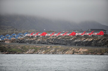 Greenland. Colorful houses dot the rugged coastline of a remote settlement in Greenland during a cloudy day