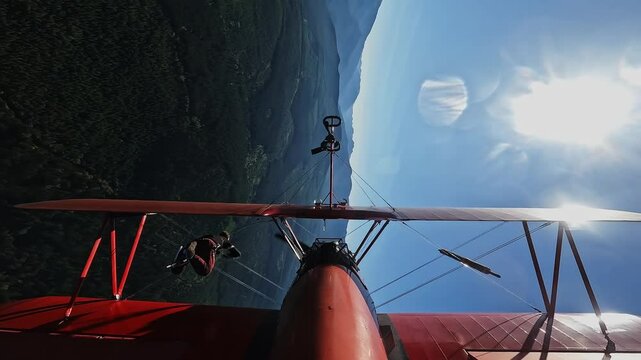 Pilot Performing Loop with Person on Airplane Wing in Flight