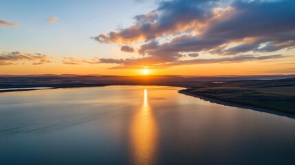 Fototapeta premium Serene Sunset Over Calm Lake and Rolling Hills