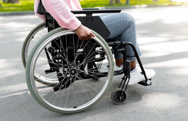 Unrecognizable handicapped black lady in wheelchair enjoying warm autumn morning at park, closeup....