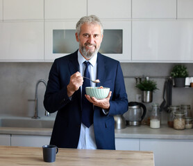 businessman busy home man mature kitchen morning breakfast business getting ready oatmeal food bowl...