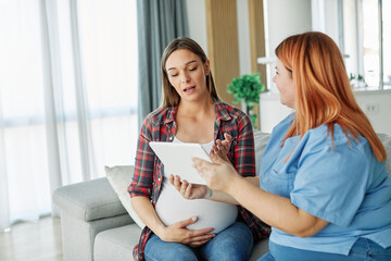 woman pregnant mother pregnancy belly patient nurse visit control exam test maternity computer visit technology hospital talking tablet support explaining