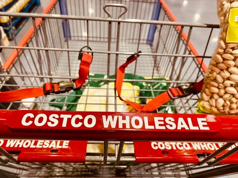 Zaragoza , Spain - January 11, 2025: A hand holds a cart at the Costco warehouse. Costco is a U.S. corporation that operates a chain of members-only warehouses