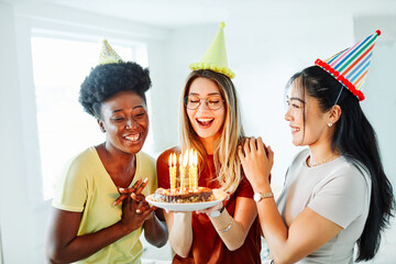 birthday celebration party cake happy candle blowing friendship fun friend woman home smiling...