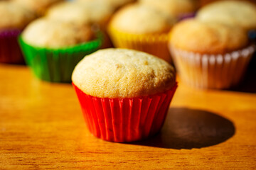 A mini banana muffin upclose with additional muffins in the background.