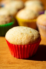 A mini banana muffin upclose with additional muffins in the background.