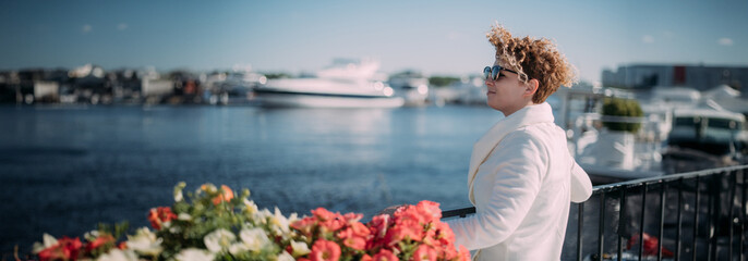 Young woman on the pier with deck yachts. A beautiful girl walks by the water near moored luxury yachts