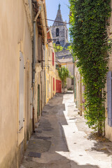 Arles, Bouches-du-Rhone, Provence-Alpes-Cote d'Azur, France. Steeple on a small church seen through an alley in Arles.