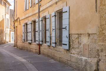 L'Isle-sur-la-Sorgue, Avignon, Vaucluse, Provence-Alpes-Cote d'Azur, France. Windows with wooden shutters along a narrow street.