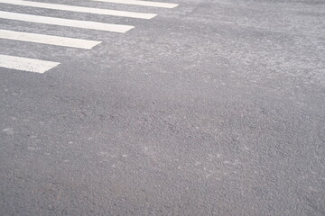 Pedestrian zebra crossing, white stripes on gray asphalt, place to cross the road, traffic rules, crosswalk on road for safety. Textured background