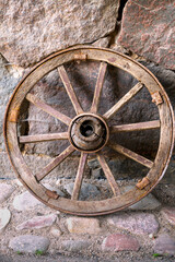 Old wooden wheel against the wall. Village life.