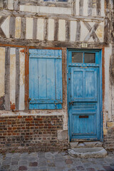 Old door and shuttered window in the French town of Honfleur in Normandy.