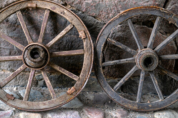 Old wooden cart wheels against the wall. Village life.