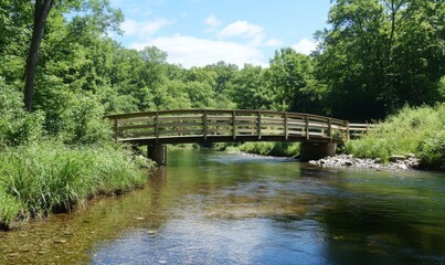 A scenic wooden bridge spanning a clear river with a lush summer backdrop, greenery, river