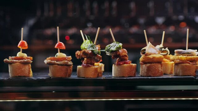 Italian or Spanish restaurant with traditional tapas pinchos food, Spanish cuisine, delicious tapas and cheese plate, bruschetta with cheese, olives dry tomatoes tasty sandwich bar appetizer, buffet