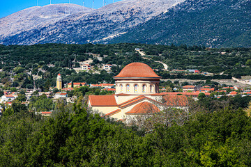 Fototapeta premium Argostoli, Greece. Red domed orthodox church, terra cotta roof, stained glass, cypress tree countryside