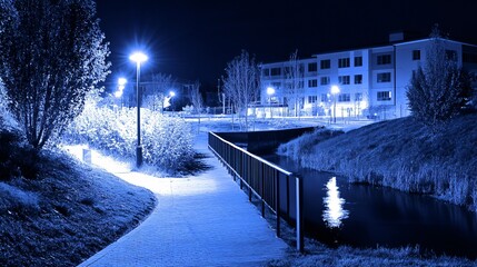 Obraz premium Night Scene, Illuminated Pathway Beside Canal, Modern Building