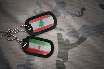 vintage army blank, dog tag with flag of lebanon and iran on the khaki texture background. military...