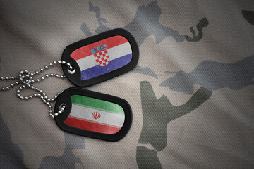 vintage army blank, dog tag with flag of croatia and iran on the khaki texture background. military...