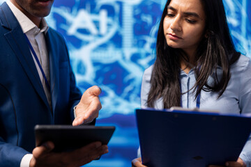 Admins use AI machine learning to extract information from complex data on tablet. Employees in...