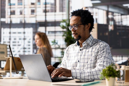 Skilled businessman at his office desk working on report writing, data analysis and deadline management. Male executive looking to expand the enterprise globally, multitasking at job. - Powered by Adobe